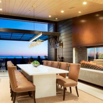 Euroline Steel Windows and Doors specialty doors in a modern dining area with ocean view.