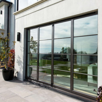 Euroline Steel Windows and Doors sliding door overlooking a backyard.
