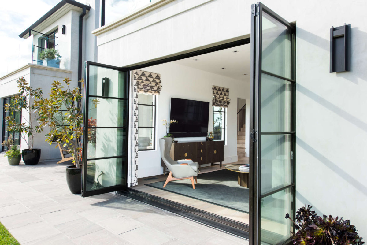 Euroline Steel Windows and Doors pivot door open to a modern interior space.