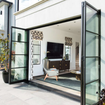 Euroline Steel Windows and Doors pivot door open to a modern interior space.