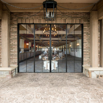 Euroline Steel Windows and Doors wine room doors opening to a grand dining area.