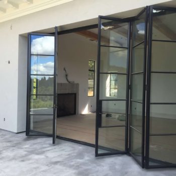 Spacious room with Euroline Steel Windows and Doors pivot door leading to an outdoor area.