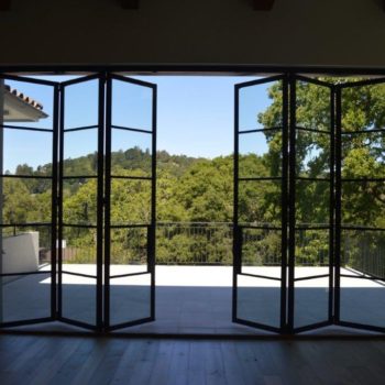 Euroline Steel Windows and Doors pivot door opening to a scenic balcony.