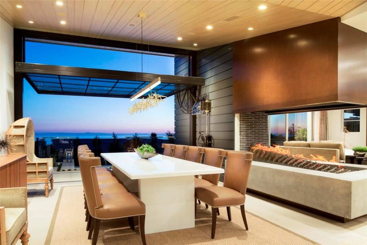 Euroline Steel Windows and Doors specialty doors in a modern dining area with ocean view.