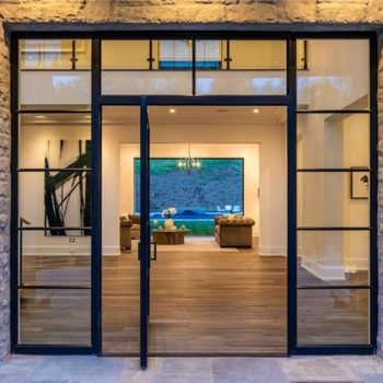 Euroline steel pivot door opening to a modern living room.