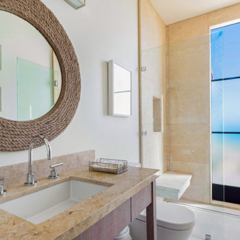 Elegant bathroom with Euroline Steel Windows and Doors specialty glass doors offering coastal views.